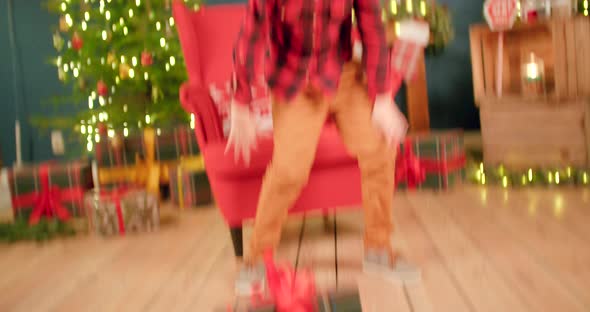 Young boy is smashing Christmas present to the ground and kicking it away alt