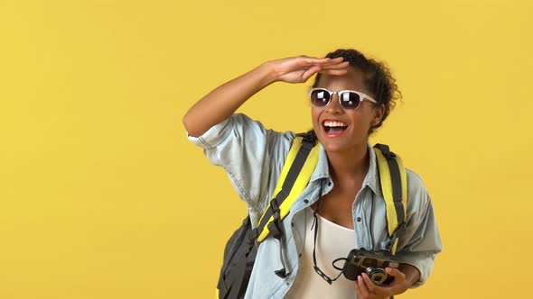 Happy surprised African American woman tourist clicking pictures on camera