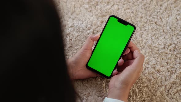 Top View Closeup View of Smartphone in Female Hands with Green Mockup Screen Chroma Key Mochup alt