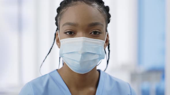 Close Up View of Woman in Medical Protective Mask Raising Head and Looking to Camera alt