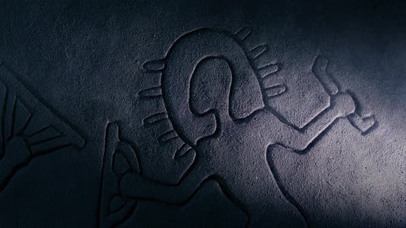 Torch Lights Up Ancient Space Man Rock Carving alt