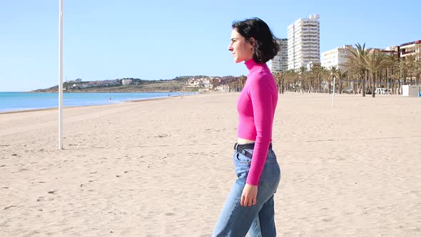 Dressed Young Woman Goes to the Sea and Looks Forward