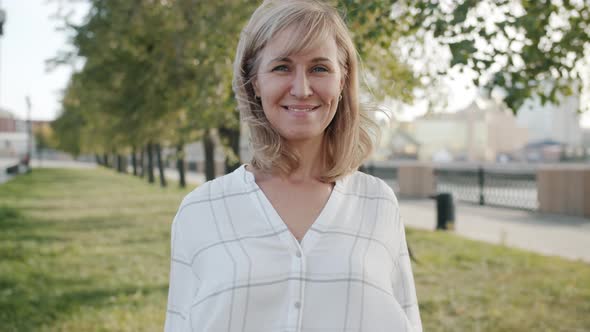 Slow Motion of Optimistic Woman Showing Okay Hand Gesture Smiling Standing Outside in City Street alt