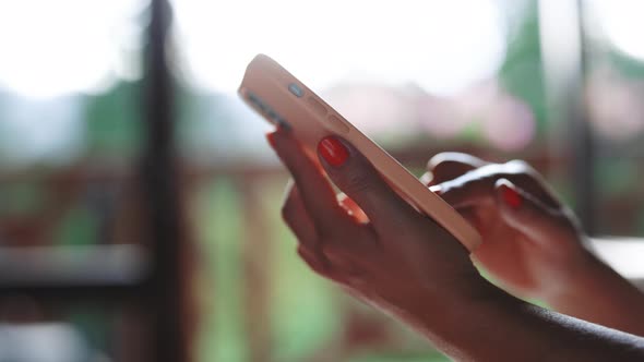 Close up of Woman Hand Using Smart Phone Browsing Online Enjoying Reading Social Media at Home