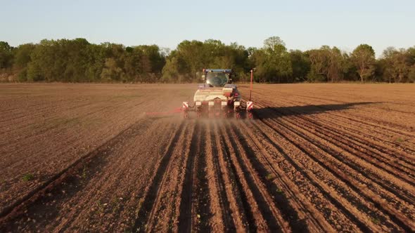 Tractor Working in Field at Sunset alt