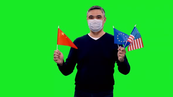 Adult Man in Protective Mask Walking with Waving Flags of China, EU and USA on Green Screen 