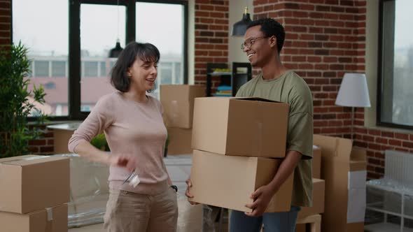 Diverse Couple Celebrating First Home Purchase to Move in Together alt
