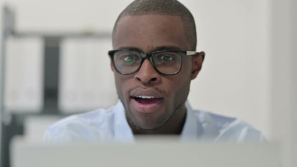 Close Up of African Man Celebrating While Using Laptop alt