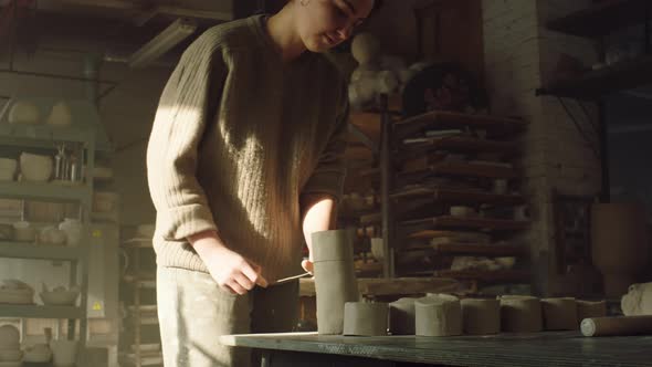 Woman Potter Is Cutting Off Clay Pieces alt