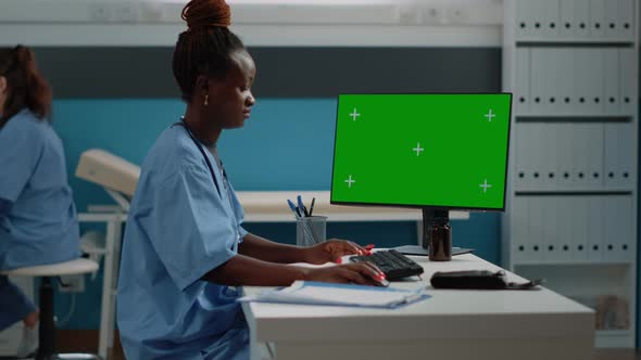 Nurse Working with Keyboard and Horizontal Green Screen alt