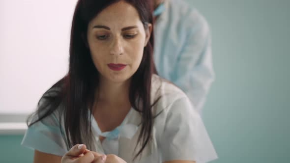 Pregnant Woman Sitting on Fitball While Man Massaging Back alt