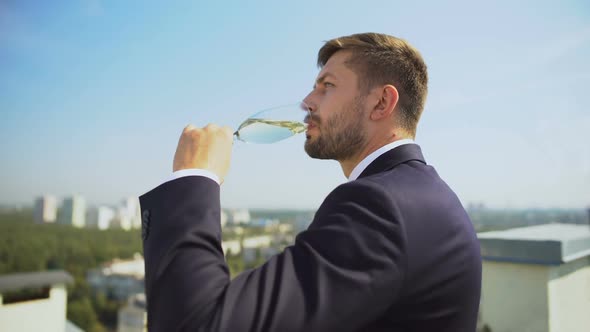 Sad Young Businessman Drinking Alcohol From Glass Outdoors, Work Problem, Crisis