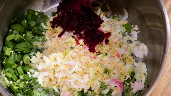 Adding beetroots next to other ingredients to make cold beetroot soup alt