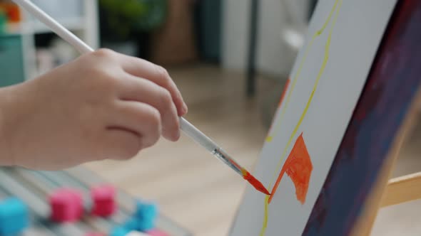 Closeup of Kid's Little Hand Painting Picture with Brush and Watercolors Enjoying Art at Home alt