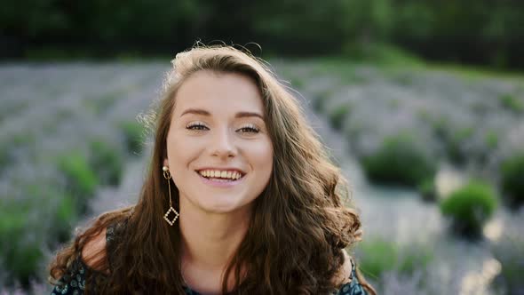 Portrait Face of Smiling Young Caucasian Brunette Woman While Standing on Lavander Field and Posing alt