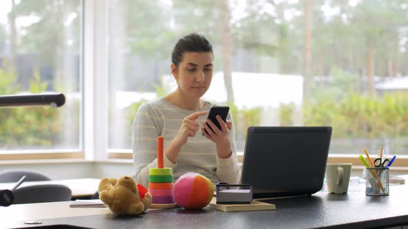 Young Woman with Smartphone Working at Home Office alt