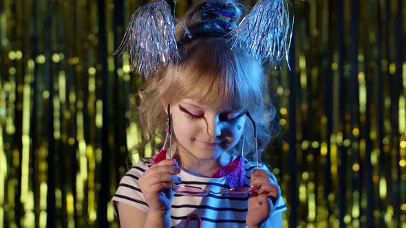 Trendy Stylish Girl Wears Pink Sunglasses Looking at Camera Smiling in Neon Light at Disco Club alt