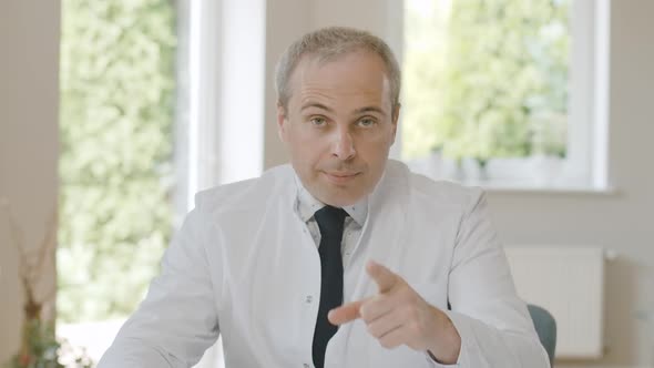 Serious Strict Doctor with Finger Raised Talking at Camera. Portrait of Confident Caucasian alt