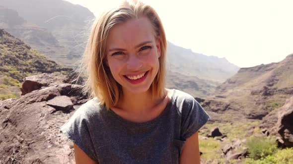 Female Model with Blonde Hair Smiling and a View of the Gran Canaria Valley alt