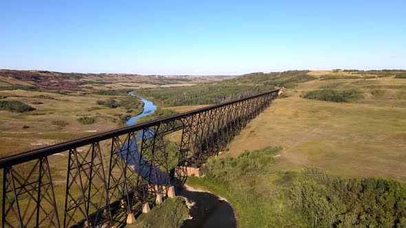 Battle River Trestle on sunny day. Aerial 4K Drone footage. Green Bushland and forests. Flyover brid alt