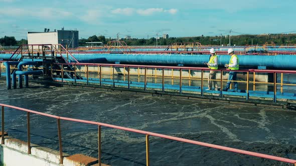 Two Specialists Examining a Clarifier at a Biological Wastewater Treatment Facility alt