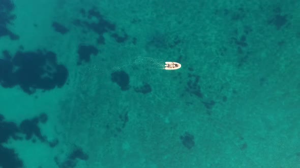 Aerial view of single speed boat floating over transparent water, Croatia. alt