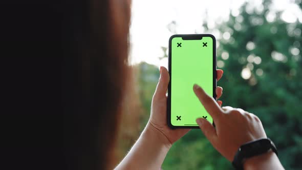 Woman Using Smartphone with Chroma Key Green Screen Scrolling Social Media or Online Shopping