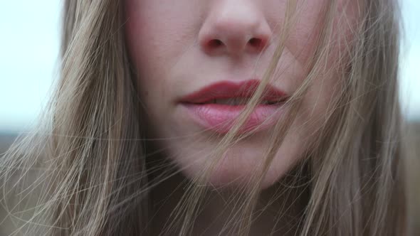 Woman's Lips Parting Amid Windswept Hair