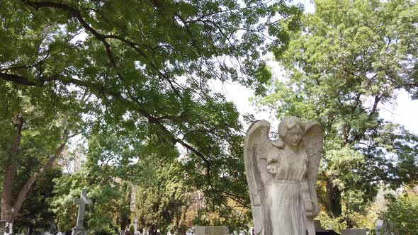 Statue of an angel in a cemetery. Funeral concept. Angel statue on gravestone. alt