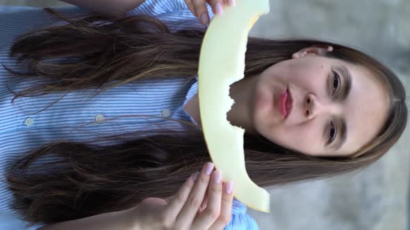 Portrait of a Beautiful Young Woman Eating Melon alt