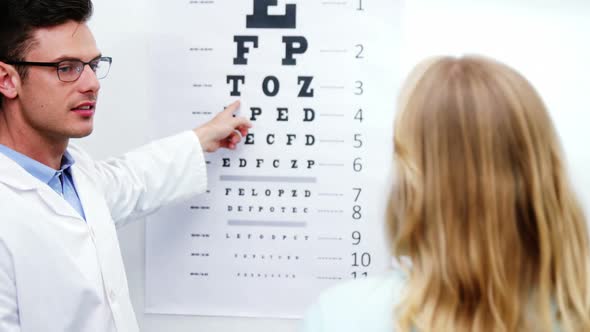 Optometrist taking eye test of female patient alt