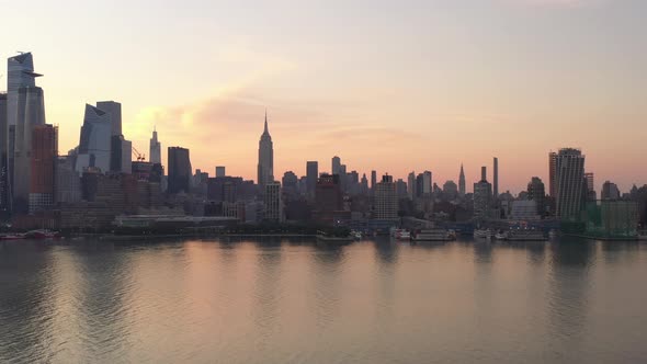 An aerial shot of Manhattan's westside at sunrise on a hazy morning. The camera tilt up and dolly in alt