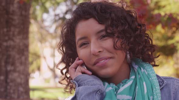 College student on campus in fall talking on cell phone