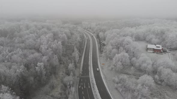 Highway Winter Road and Snowy Forest Landscape Aerial