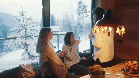 Happy Young Women Celebrating New Year in Wooden Mountain Hut alt