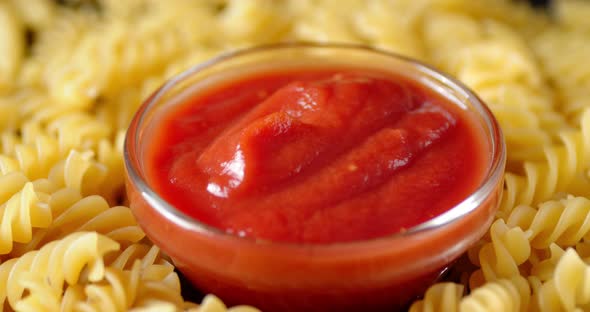 Dry Pasta Fusilli with Tomato Sauce Slowly Rotates.  alt