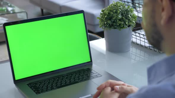 Hands of man at chroma key green screen laptop computer gesturing during an online video alt