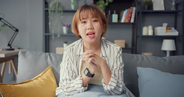 Asia businesswoman using laptop talk to colleagues about plan in video call while working . alt