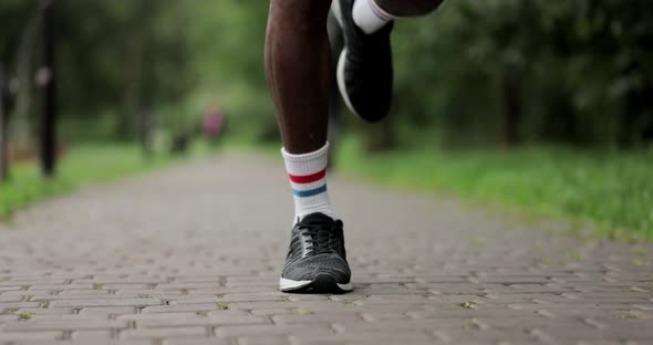 Close Up Man Legs Athlete Runner Runs in a Park in the City is Training alt