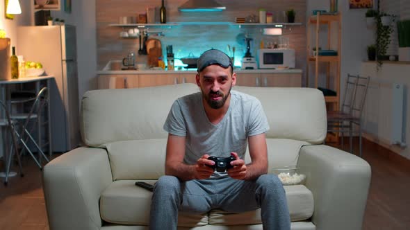 Upset Pro Gamer Sitting in Front of Television Losing Soccer Video Games alt