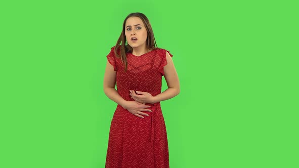 Tender Girl in Red Dress Is Feeling Very Bad, Her Stomach Hurting. Green Screen alt