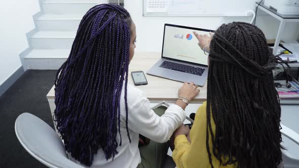 Two African American women working in the office. alt