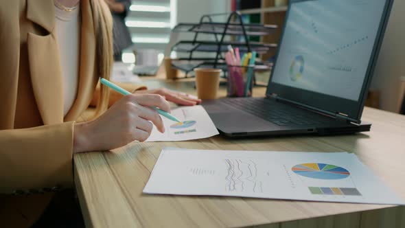 Close up Bsiness woman hands working using laptop looking through analytic data. alt
