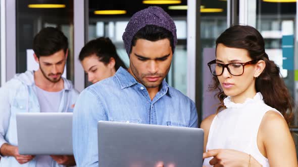 Executives discussing over laptop alt