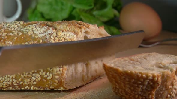 Knife Cutting Baguette with Sesame Seeds alt