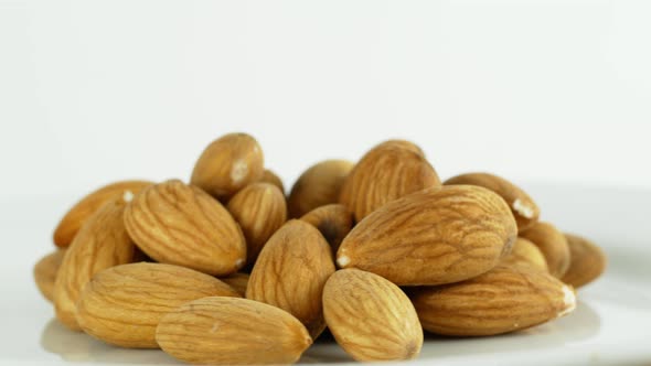 Healthy nuts almonds rotate on a white background 360. Eco cereals vegetarian. Nuts on a white plate
