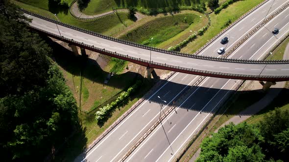 Aerial birds eye shot of cars and trucks driving on highway during sunny day alt