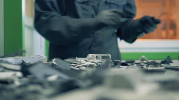 A Man Sorts Metal Trash on Plant Conveyor. alt