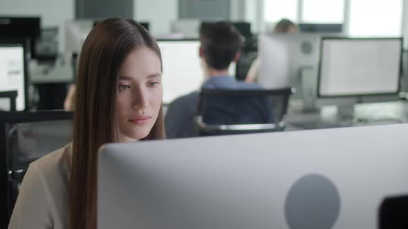 Attractive Young Woman Working on Decktop Computer While Working in Big Open Space Office alt