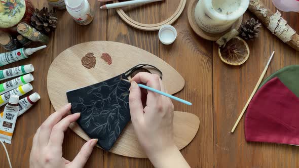 Women's Hands Draw Leaves on Medical Mask with Brush and Paint